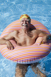 Österreich, Älterer Mann mit Schwimmreifen im Schwimmbad, lächelnd, Porträt - MAEF01893