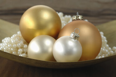Christmas decoration, Christmas baubles and pearls in bowl, close-up - ASF03939