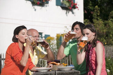 Deutschland, Bayern, Freunde trinken Bier im Garten - WESTF13272