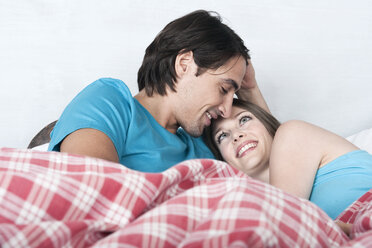 Germany, Bavaria, Young couple lying in bed - WESTF13200