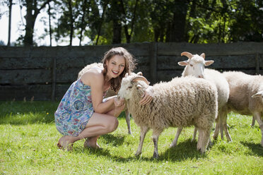 Germany, Bavaria, Young woman feeding sheep, portrait - WESTF13195