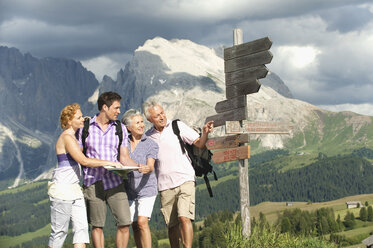 Italien, Seiseralm, Vier Personen stehen neben einem Wegweiser - WESTF13436