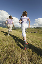 Italien, Seiseralm, Mädchen (6-7), (8-9) laufen auf einer Wiese, Rückansicht - WESTF13432