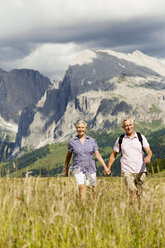 Italien, Seiseralm, Seniorenpaar wandert Hand in Hand - WESTF13411