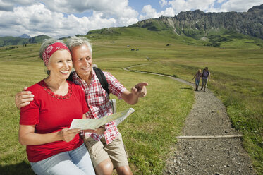 Italy, Seiseralm, Senior couple holding map, smiling, portrait - WESTF13398