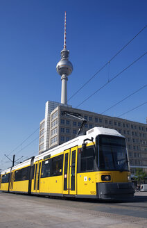 Deutschland, Berlin, Gelbe Straßenbahn, Fernsehturm im Hintergrund - PSF00403