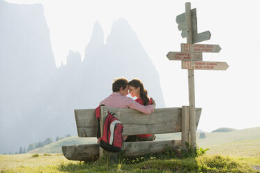 Italien, Südtirol, Seiseralm, Pärchen sitzt auf Bank, Kopf an Kopf - WESTF13726