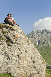 Italy, South Tyrol, Couple sitting on rock, taking a break - WESTF13716