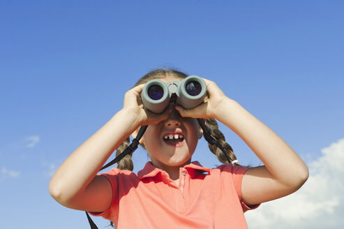 Italy, South Tyrol, Girl (6-7) using binoculars, portrait - WESTF13708