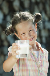 Italien, Südtirol, Mädchen (6-7) mit einem Glas Milch in der Hand, lächelnd, Porträt, Nahaufnahme - WESTF13686