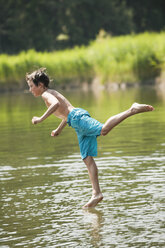 Italy, South Tyrol, Boy (10-11) jumping into lake - WESTF13634