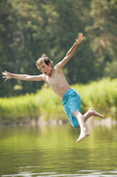 Italy, South Tyrol, Boy (10-11) jumping into lake - WESTF13633