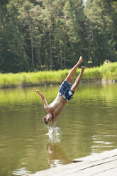Italy, South Tyrol, Man jumping into lake - WESTF13632