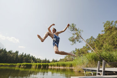 Italy, South Tyrol, Man jumping into lake - WESTF13626