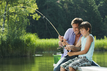 Father and son fishing with nets in pond - Stock Image - F015/5153 -  Science Photo Library