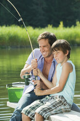 Italy, South Tyrol, Father and son (10-11) fishing - WESTF13612