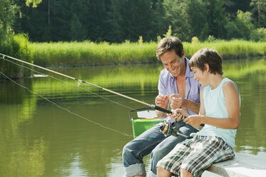 Italy, South Tyrol, Father and son (10-11) fishing - WESTF13611