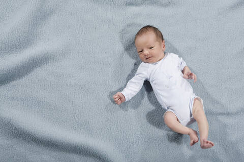 Baby-Mädchen (0-4 Wochen) auf Decke liegend, Ansicht von oben, lizenzfreies Stockfoto