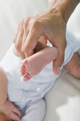 Father holding baby girls (0-4 weeks) foot, elevated view - LDF00814