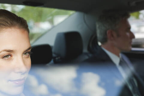 Germany, Hamburg, Business people sitting in car, looking out of window, portrait stock photo