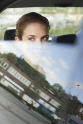 Germany, Hamburg, Business woman sitting in car, lookitng out of window, portrait - WESTF13881