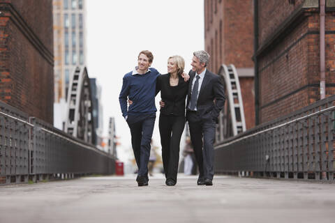 Germany, Hamburg, Three Business people crossing bridge stock photo