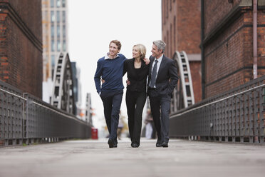 Germany, Hamburg, Three Business people crossing bridge - WESTF13873