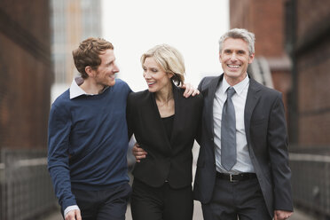 Germany, Hamburg, Three Business people walking side by side, smiling, portrait - WESTF13872