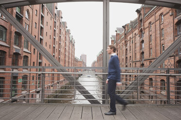 Deutschland, Hamburg, Geschäftsmann überquert Brücke, Seitenansicht - WESTF13867