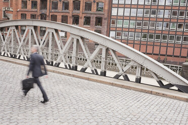 Deutschland, Hamburg, Geschäftsmann beim Überqueren einer Brücke - WESTF13863