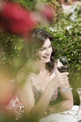 Italien, SüdtirolFrau im Restaurant mit einem Glas Rotwein in der Hand, lächelndes Porträt - WESTF13766