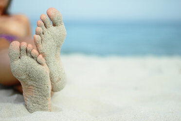 Italien, Sardinien, Person liegend am Strand, sandige Füße - MBEF00012