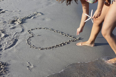 Italy, Sardinia, Person drawing heart in sand - MBEF00011