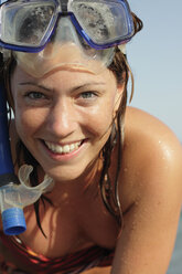 Italy, Sardinia, Woman on beach wearing snorkel mask, portrait - MBEF00006
