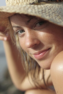 Italien, Sardinien, Junge Frau am Strand mit Strohhut, Porträt, Nahaufnahme - MBEF00001