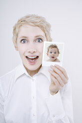 Frau hält Baby Foto, Porträt - TCF01269