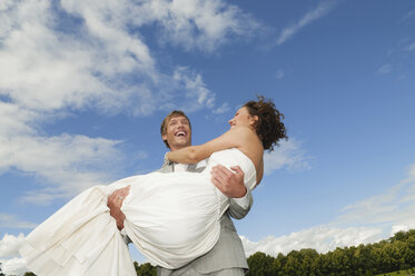 Germany, Bavaria, Groom lifting bride, laughing, portrait - NHF01137