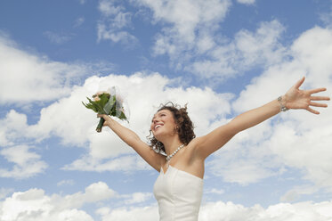 Germany, Bavaria, Smiling Bride with bouquet and arms outstreched , outdoors - NHF01124