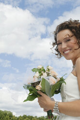 Germany, Bavaria, Smiling Bride with bouquet, outdoors, portrait, close-up - NHF01122