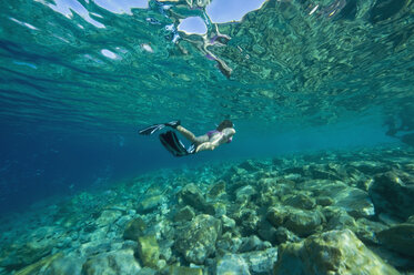 Croatia, Girl (10-11) snorkeling, rear view - GNF01166