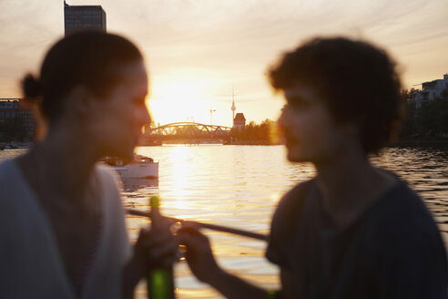 Deutschland, Berlin, Junges Paar auf Boot, Flaschen in der Hand, Seitenansicht, Porträt - VVF00102