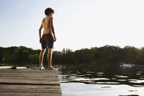 Germany, Berlin, Spree river, Young man standing on jetty stock photo