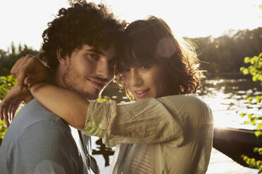 Germany, Berlin, Young Couple embracing by River Spree, side view, portrait, close-up - VVF00084