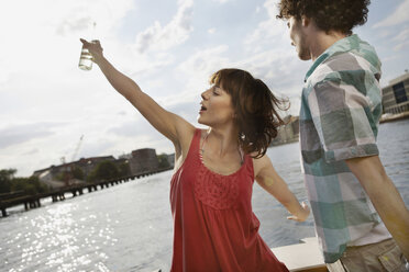 Germany, Berlin, Young couple on motor boat, woman dancing - VVF00061