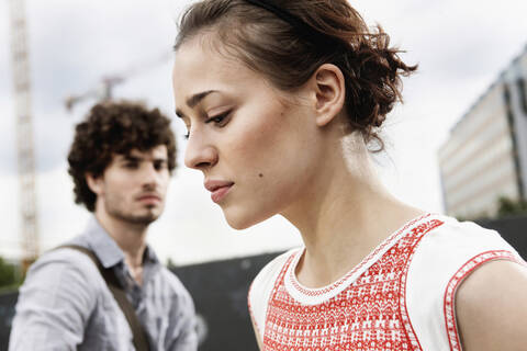 Germany, Berlin, Young couple, woman looking down, side view, portrait, close-up stock photo