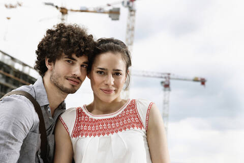 Germany, Berlin, Young couple in front of new building, cranes in background stock photo