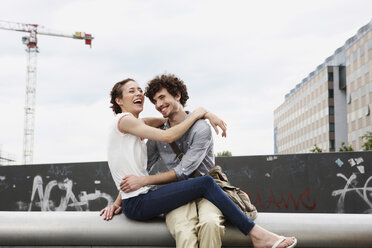 Germany, Berlin, Young couple in front of new building, cranes in background - VVF00020