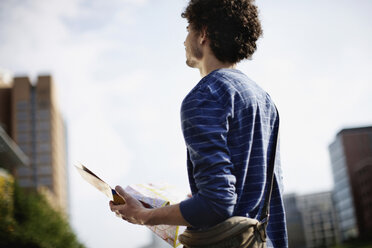 Germany, Berlin, Young man holding city map - VVF00013