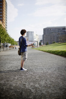 Deutschland, Berlin, Junger Mann mit Stadtplan - VVF00012