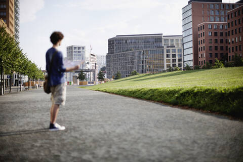 Germany, Berlin, Young man holding city map stock photo